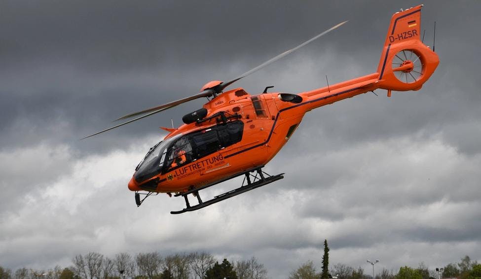 Oransjet helikopter som lander på platform